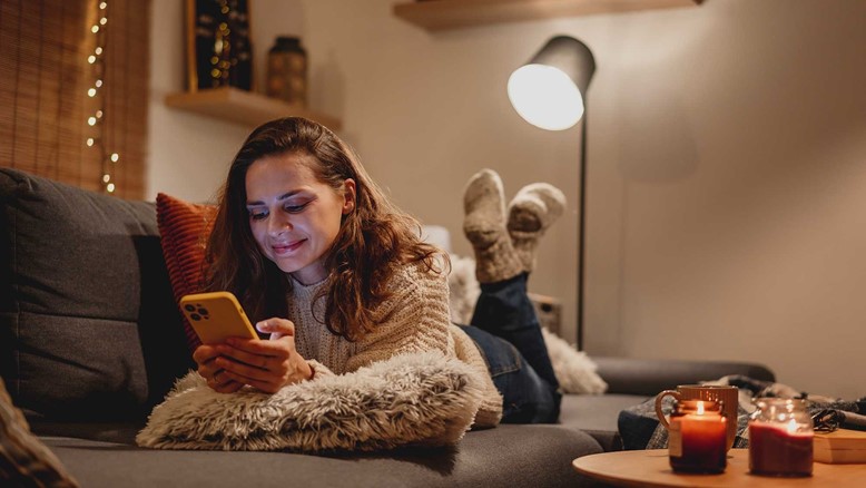 Γυναίκα στον καναπέ με κινητό